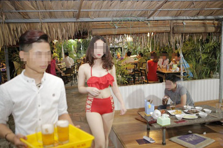 Nhân viên mặc bikini tại một quán ăn trên đường Trần Thái Tông (Cầu Giấy) để rót bia, bưng đồ ăn phục vụ khách.