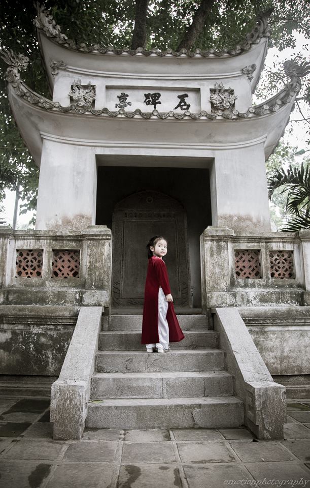 
Những bức tường rêu trầm mặc nơi cửa chùa trở vốn quen thuộc với hình ảnh chú tiểu mặc áo dài, nay trở nên vừa cổ hơn, vừa hiện đại hơn với sự xuất hiện của em bé Hà Nội áo dài nhung đỏ.
