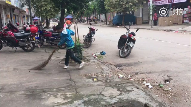 
Cậu bé 12 tuổi cặm cụi đi dọn dẹp phố phường giúp bố mẹ.
