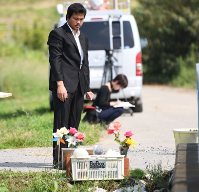 
Anh Lê Anh Hào đến thắp hương cho bé Linh tại nơi tìm thấy thi thể bé, 6 tháng sau vụ sát hại. Ảnh: Kyodo.
