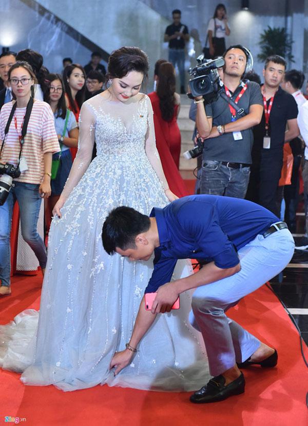 
Chồng Bảo Thanh nâng váy giúp vợ để cô tiện di chuyển.
