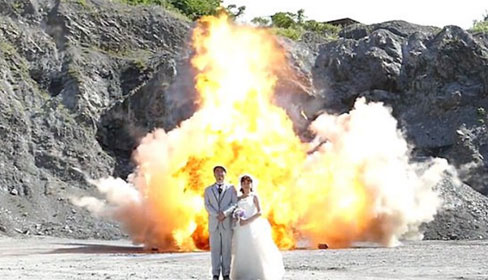 
Cặp vợ chồng bất chấp nguy hiểm chụp ảnh bên cạnh vụ nổ.
