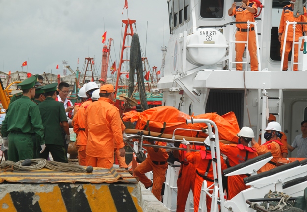 
Lực lượng tìm kiếm cứu nạn đưa thi thể sĩ quan máy trên tàu VTB 26 Nguyễn Văn Dương lên bờ. ẢNH: V. Đồng
