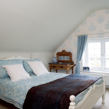 Phòng ngủ ở gian áp mái vẫn mang đến cảm giác thoải mái cho người sử dụng khi kết hợp giữa xanh và trắng. Màu xanh nhạt với hoa văn đơn giản tạo nên cảm giác đang ở bên bờ biển mát mẻ và trong lành.