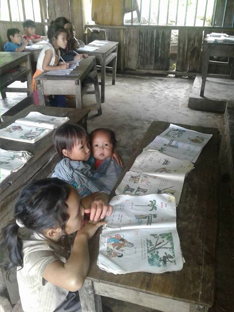 
Bức ảnh em Hồ Thị Nhung địu em 8 tháng tuổi đến lớp học làm lay động dân mạng (ảnh Trần Tuấn)
