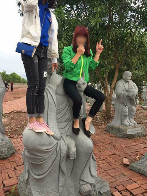 
H&agrave;nh động leo l&ecirc;n tượng Phật chụp ảnh của hai thiếu nữ g&acirc;y bức x&uacute;c.
