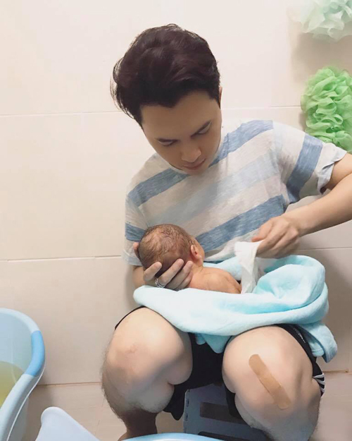 
Nam Cường chia sẻ hình ảnh khéo léo bế con trai sau khi tắm xong cho cậu bé.
