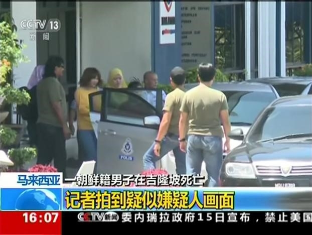 Ảnh chụp từ video của Đài truyền hình trung ương Trung Quốc cho thấy người phụ nữ nghi phạm (áo vàng), nghi can trong vụ ông Kim Jong Nam chết ở sân bay, đang được giải khỏi đồn cảnh sát. Ảnh:CCTV/Reuters.