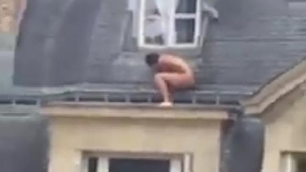 
Người đàn ông co ro núp bên ngoài cửa sổ căn hộ cao tầng ở Paris. Ảnh chụp từ video
