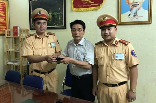 Tổ c&ocirc;ng t&aacute;c CSGT đội 1 trao trả v&iacute; cho &ocirc;ng Mi&ecirc;ng. Ảnh: Sơn Dương