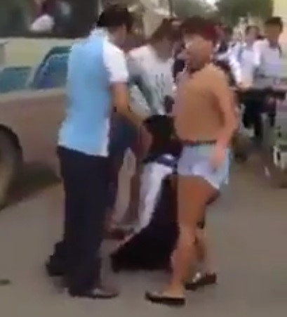 
Hình ảnh phụ nữ bắt nữ sinh quỳ trước cổng trường. Ảnh cắt từ clip.
