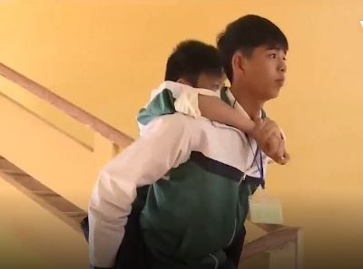 
Minh Quang c&otilde;ng bạn đến trường học trong suốt 8 năm qua. Ảnh cắt từ clip.

