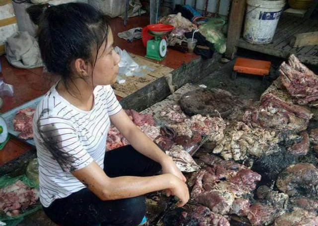 
Chị Xuyến ngồi thất thần trước khoảng một tạ thịt bị đổ chất bẩn. Ảnh: Facebook.
