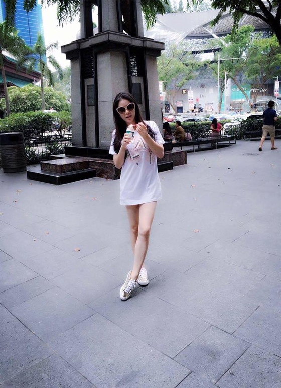 Lý Nhã Kỳ lựa chọn váy cotton trắng kết hợp giày sneaker bạc khoe đôi chân dài thon thả, nuột nà ra phố.