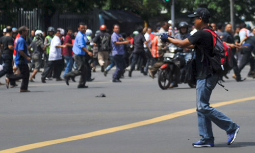 
Một kẻ tấn c&ocirc;ng chĩa s&uacute;ng v&agrave;o cảnh s&aacute;t v&agrave; đ&aacute;m đ&ocirc;ng ở Jakarta hồi th&aacute;ng 1/2016. Ảnh Reuters
