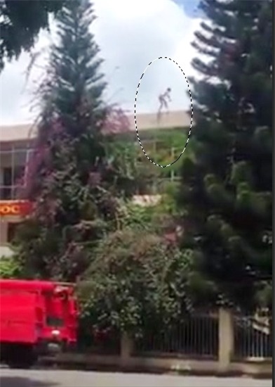 Giang leo lên nóc trụ sở Công an TP Bảo Lộc cố thủ. (Ảnh cắt từ video clip).
