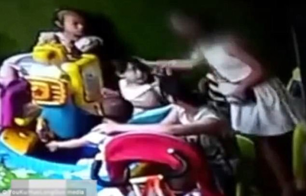 
Người phụ nữ mặc váy trắng tát mạnh hai phát vào sau đầu của bé gái 2 tuổi vì giành đồ chơi với con mình.
