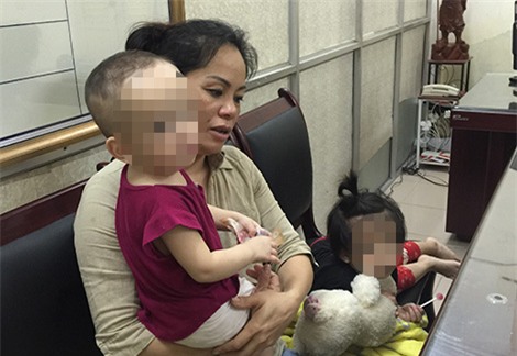 
Nguyễn Thanh Loan mang theo 2 con nhỏ khi l&ecirc;n cơ quan C&ocirc;ng an.
