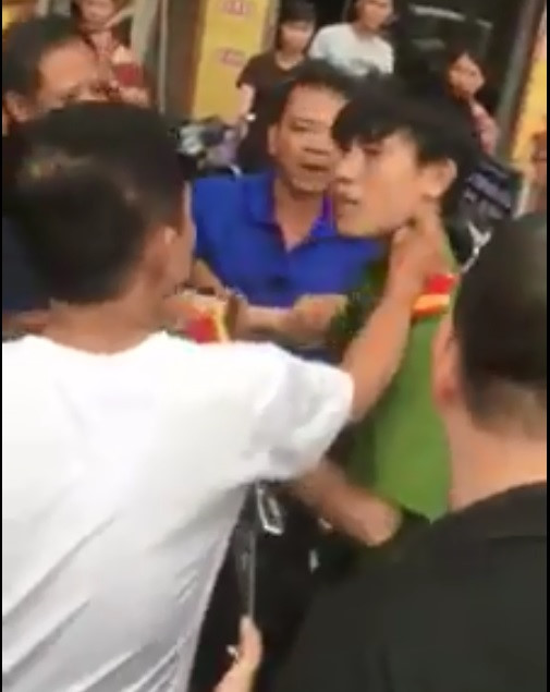 
Nam thanh ni&ecirc;n bị người d&acirc;n t&uacute;m &aacute;o, đ&aacute;nh tr&ecirc;n phố. Ảnh cắt từ clip.

