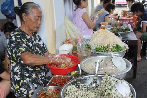 
Bà Mông liên tay trộn mít cho khách. Ảnh: Cẩm Duyên.
