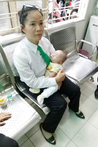 Chị Vũ Thị Hiền, t&agrave;i xế một h&atilde;ng taxi đang bế b&eacute; trai 2 th&aacute;ng tuổi bị mẹ bỏ rơi khi đến bệnh viện Gia Định