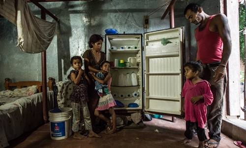 Tủ lạnh chỉ toàn chai nước của một gia đình ở Venezuela. Ảnh: NYT