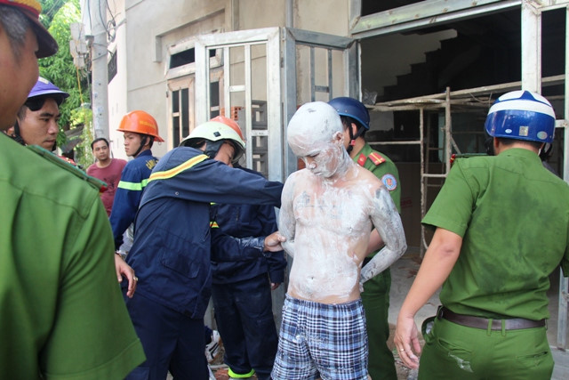 Nam thanh niên bôi vôi lên người, trèo lên nhà. Ảnh: Mai Vinh.