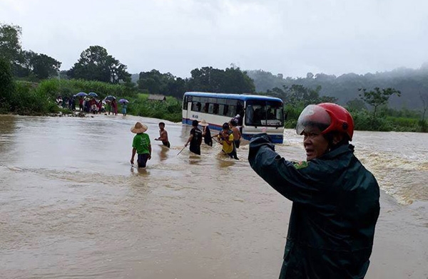 Công an xã, dân quân và người dân cùng néo dây thừng để đưa 47 học sinh vào bờ an toàn.