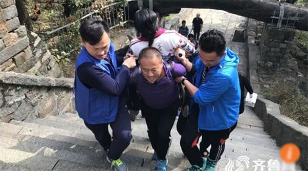 Zhang c&otilde;ng vợ tr&ecirc;n lưng với sự hỗ trợ của một v&agrave;i người bạn.