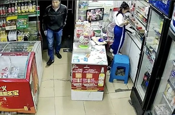 Huang bước vào cửa hàng, nhìn xung quanh trước khi bắt cóc bé gái.