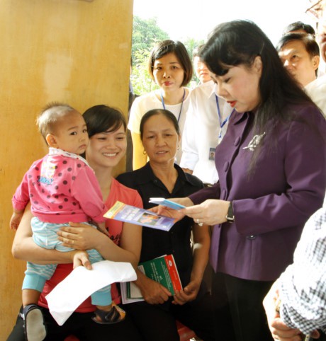 
Bộ trưởng Nguyễn Thị Kim Tiến hỏi thăm người dân đang chờ khám sức khỏe tại trạm y tế xã Mai Đình, Sóc Sơn. Ảnh: KTĐT
