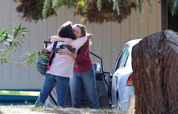 2 phụ nữ an ủi nhau phía ngoài ngôi trường nơi nghi phạm ra tay. Ảnh: AP.