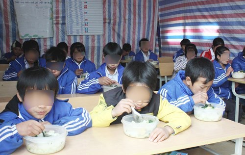 
Học sinh trường dân tộc bán trú ăn trưa trên lớp học tạm - Ảnh chỉ có tính minh họa
