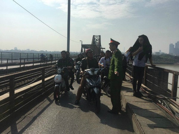 Người đi đường hiếu kỳ dừng lại xem bộ đội tiến hành trục vớt quả bom.