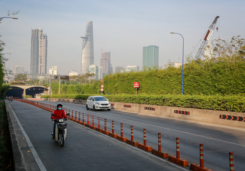 Cùng thời điểm, hầm Thủ Thiêm xuyên lòng sông Sài Gòn chỉ lác đác vài người qua lại (trái) trong khi thường ngày tấp nập xe của người dân từ quận 1 sang quận 2 (phải) và ngược lại.