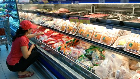 Giá gà bán tại trại giảm nhưng giá thịt gà bán đến tay người tiêu dùng vẫn không giảm. Trong ảnh: Khách hàng chọn mua thịt gà trong siêu thị