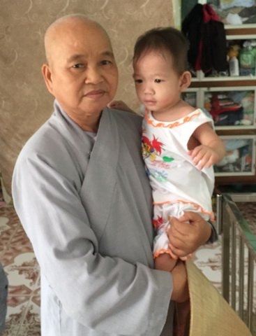 Sư cô Huệ Đức và một trẻ mồ côi.