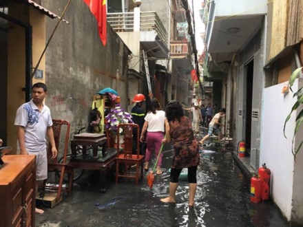 Người dân các nhà bên cạnh phải di chuyển đồ đạc ra ngoài để tránh lửa lan sang. Ảnh N.C