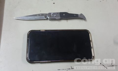 Chiếc điện thoại tang vật cùng con dao được bọn cướp dùng để đâm nhân viên bảo vệ.