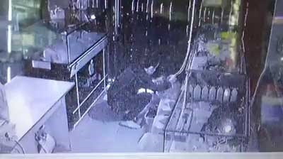 Tên trộm đang gom điện thoại bỏ vào ba lô. Ảnh: Cắt từ clip.
