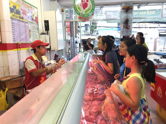 Khách xếp hàng mua thịt tại cửa hàng Vissan trên đường Nơ Trang Long chiều 10/6. Ảnh: NLĐ     