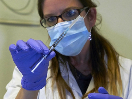 
Nữ y tá cầm kim tiêm chứa văcxin Ebola. Ảnh: Reuters.
