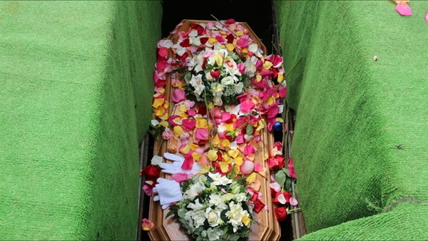 Quan tài của em ngập tràn hoa.