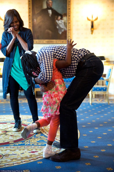 
Đệ nhất phu nhân Michelle đứng nhìn khi chồng ôm chầm cô bé Caprina Harris hôm 28/3/2016. Cô bé trở nên nổi tiếng sau khi video quay cảnh bé bật khóc lúc nghe tin nhà Obama sẽ rời Nhà Trắng trong tháng 1 này.

