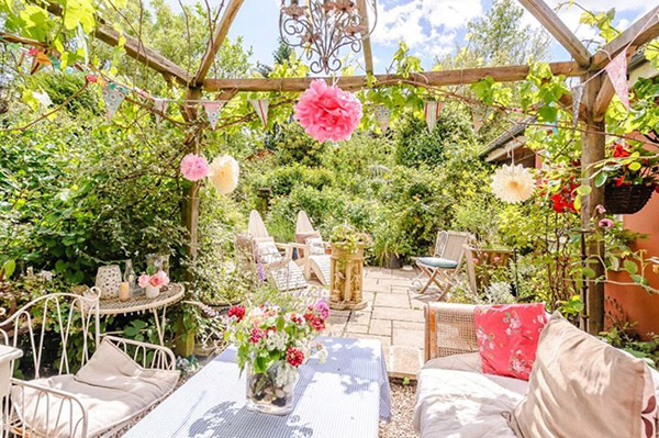 Bên ngoài có một mái hiên rộng, được bố trí bàn ghế kiểu vintage tuyệt đẹp, ngay cạnh một khu vườn ngập hoa hồng, cây cảnh.