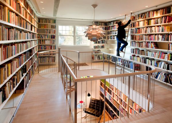 16. Giá sách 2 tầng kết hợp hoàn hảo với cầu thang trong thiết kế này. Được bao bọc bởi gỗ và lan can bằng sắt, 1 hành trình lên xuống thú vị với các bức tường sách và cầu thang.