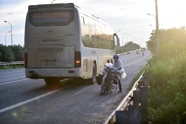 C&oacute; xe kh&aacute;ch c&ograve;n đ&oacute;n trả h&agrave;ng ngay tr&ecirc;n đường đại lộ.