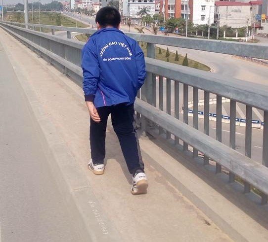 Một người con của chị Huệ nhặt đinh trên cầu Nhật Tân. Ảnh: FBNV.