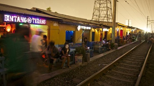 
Gái mại dâm ngồi chờ khách bên đường tàu, trước những nhà chứa bình dân ở Kalijodo năm 2013. Ảnh: News
