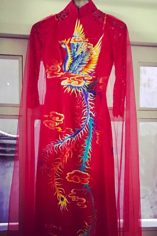 
Áo dài cưới của Nguyệt Ánh màu đỏ rực, họa tiết hình chim phượng nổi bật.
